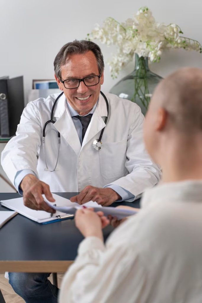A Doctor passing paper to a person opposite a table