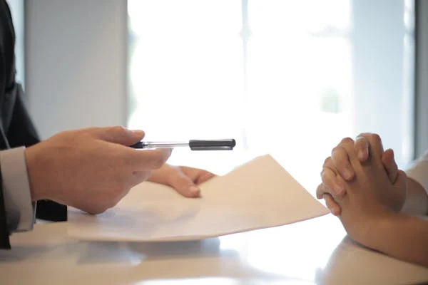 A pan and paper being passed over a table